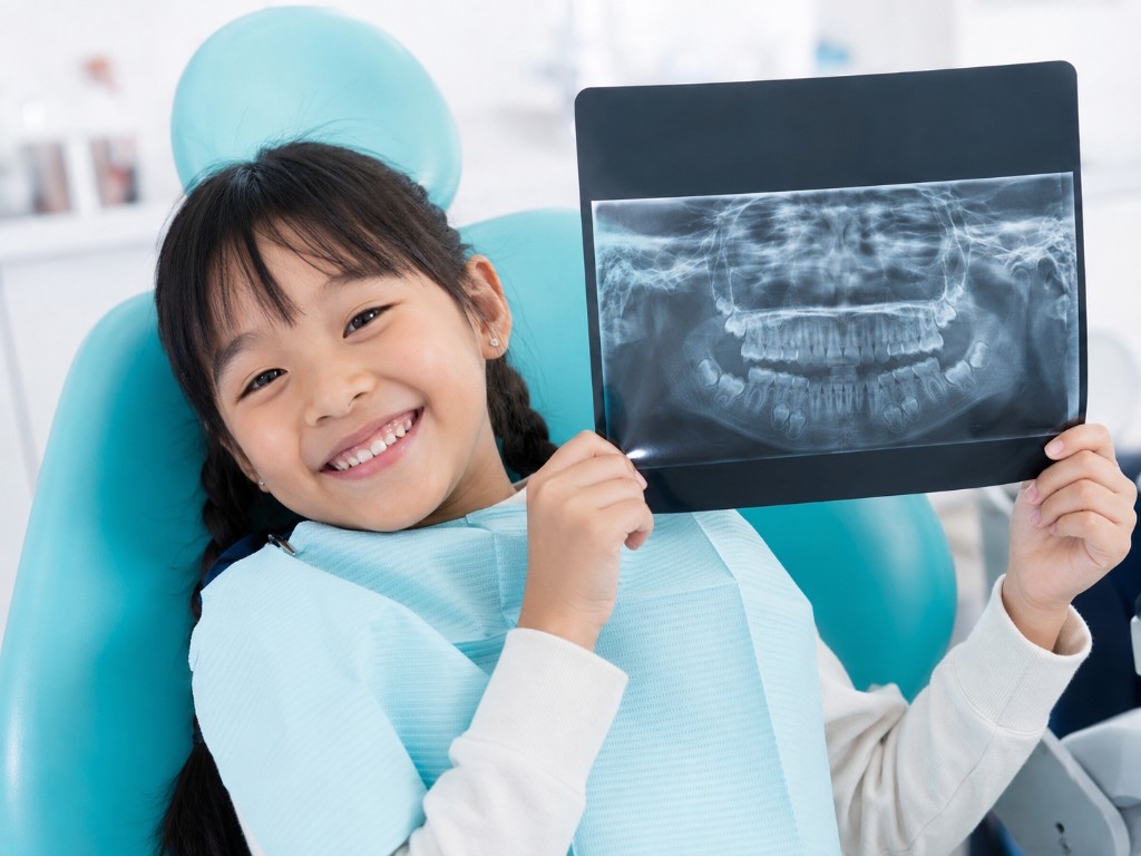 Child patient holding a dental X-ray at the clinic